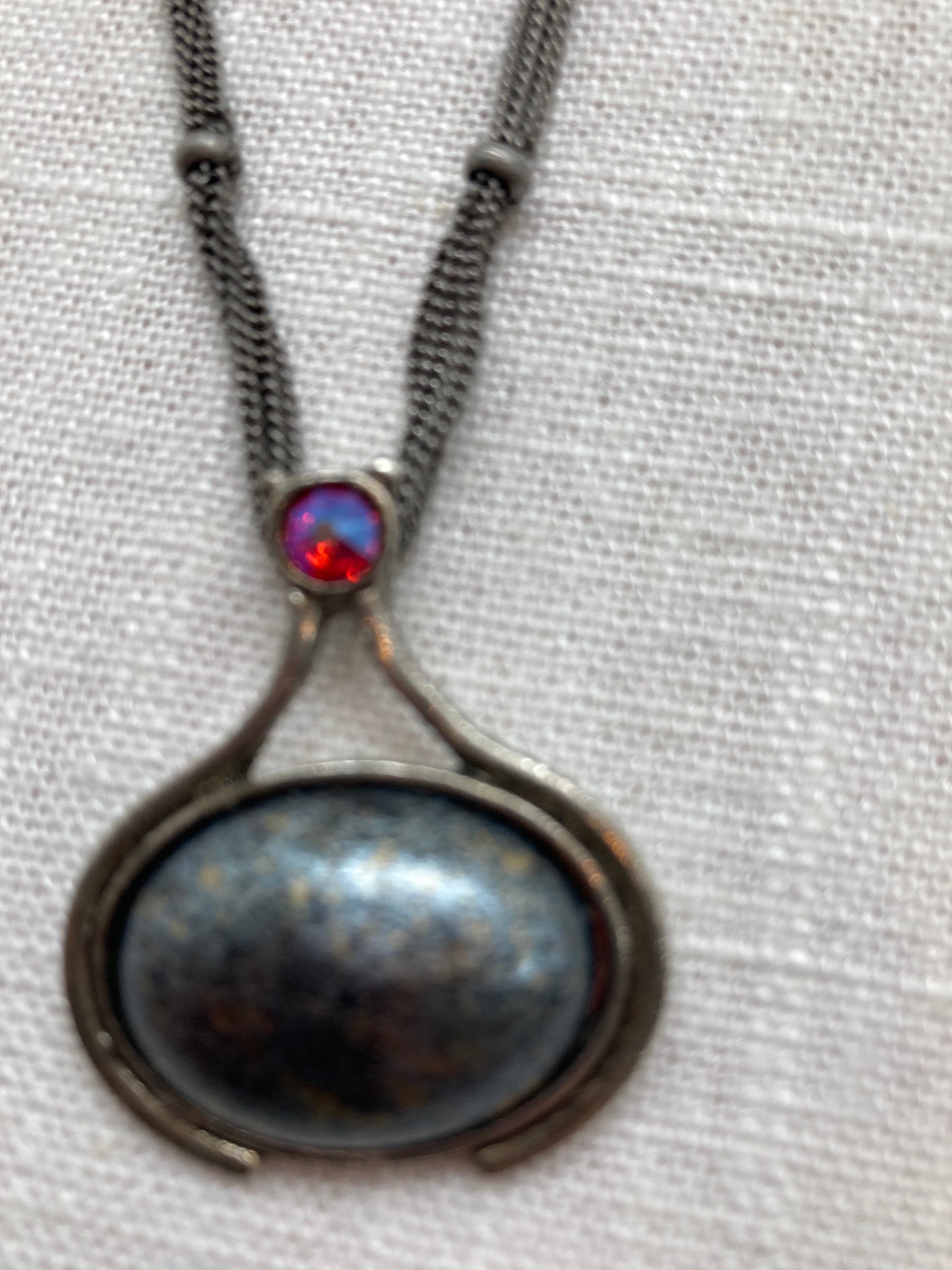 smooth gray pendant with red crystal