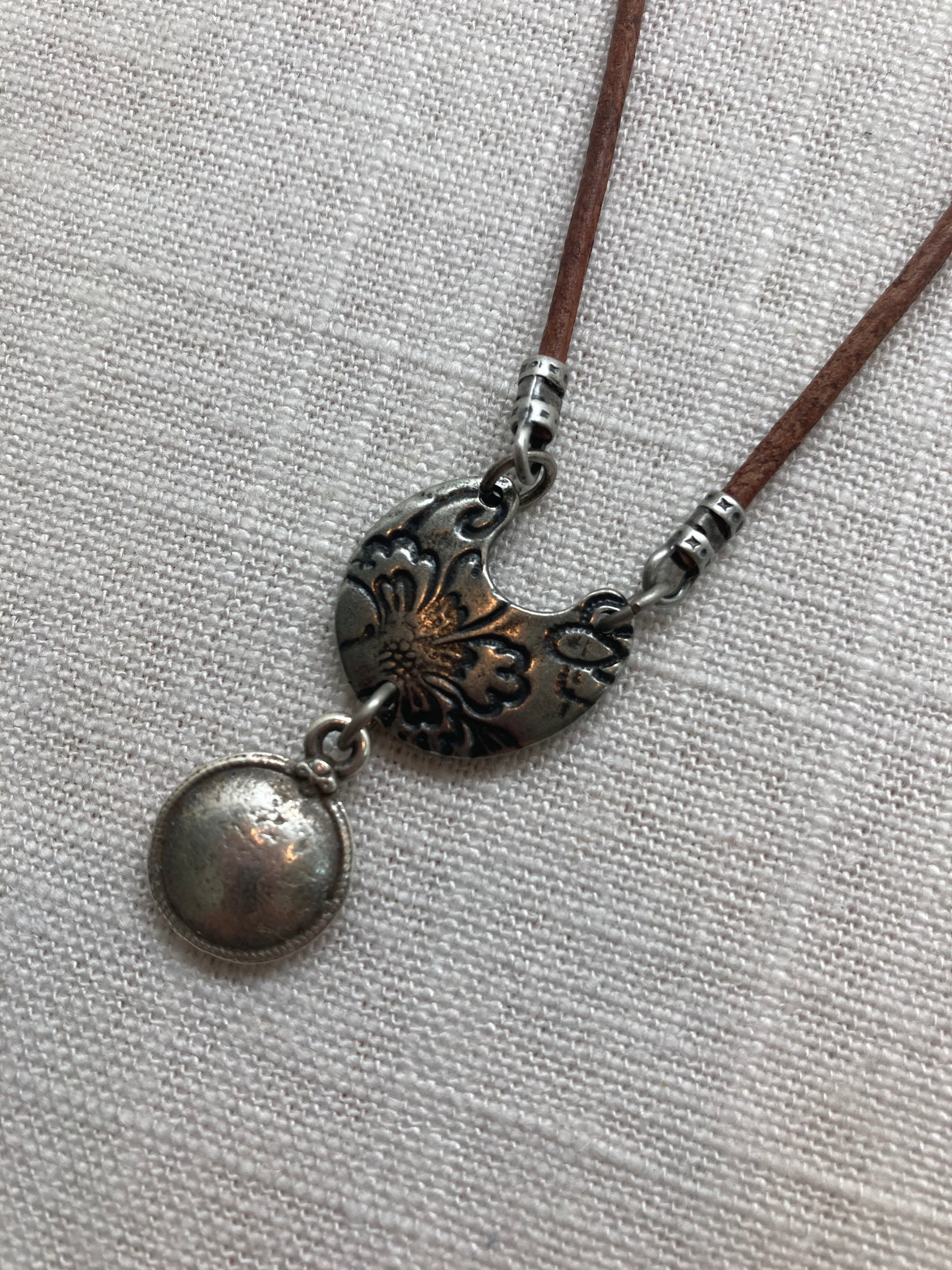 solid antique silver plated charm on brown leather necklace