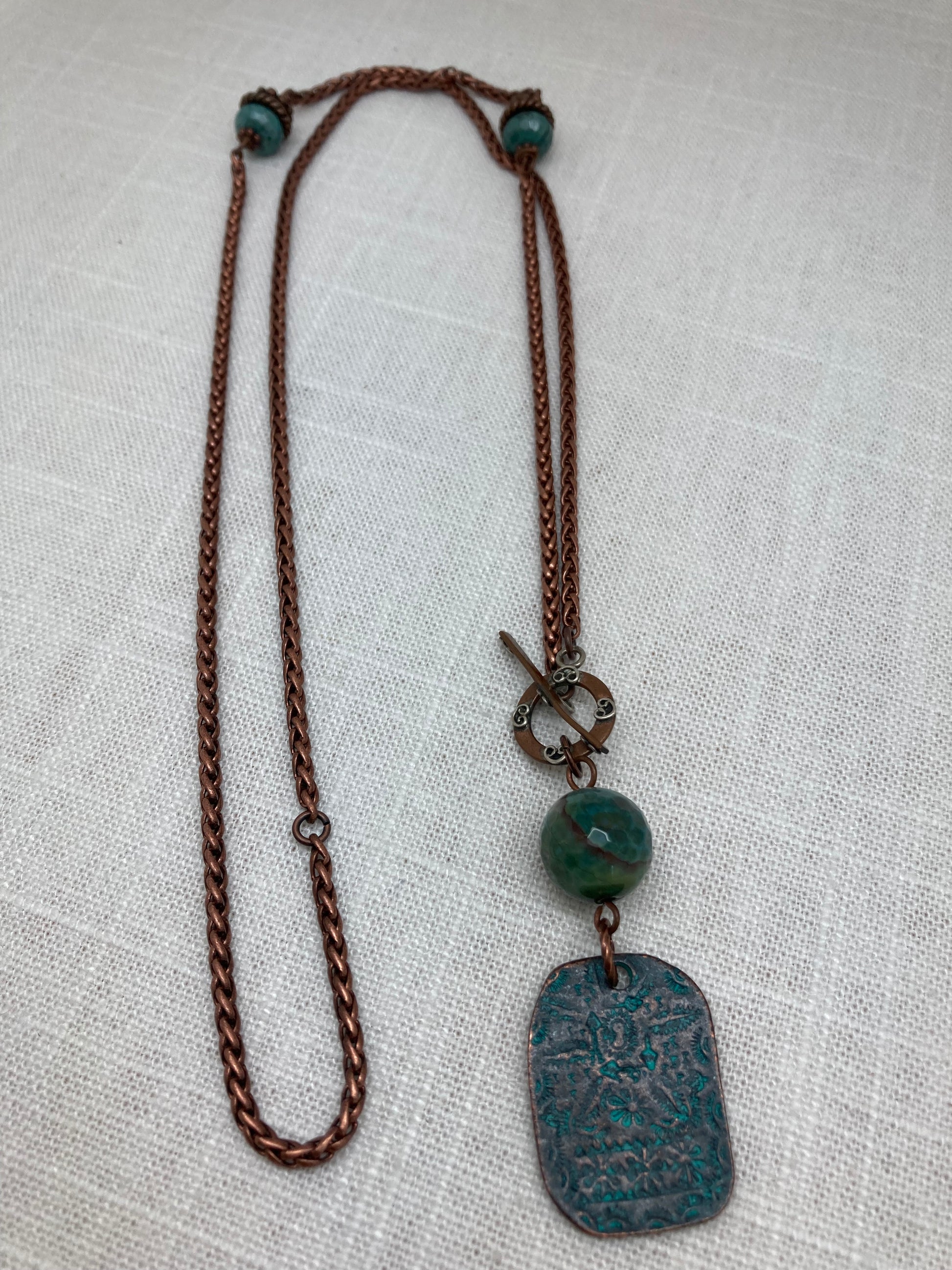 long copper necklace with patina floral stamped copper tag and agate beads