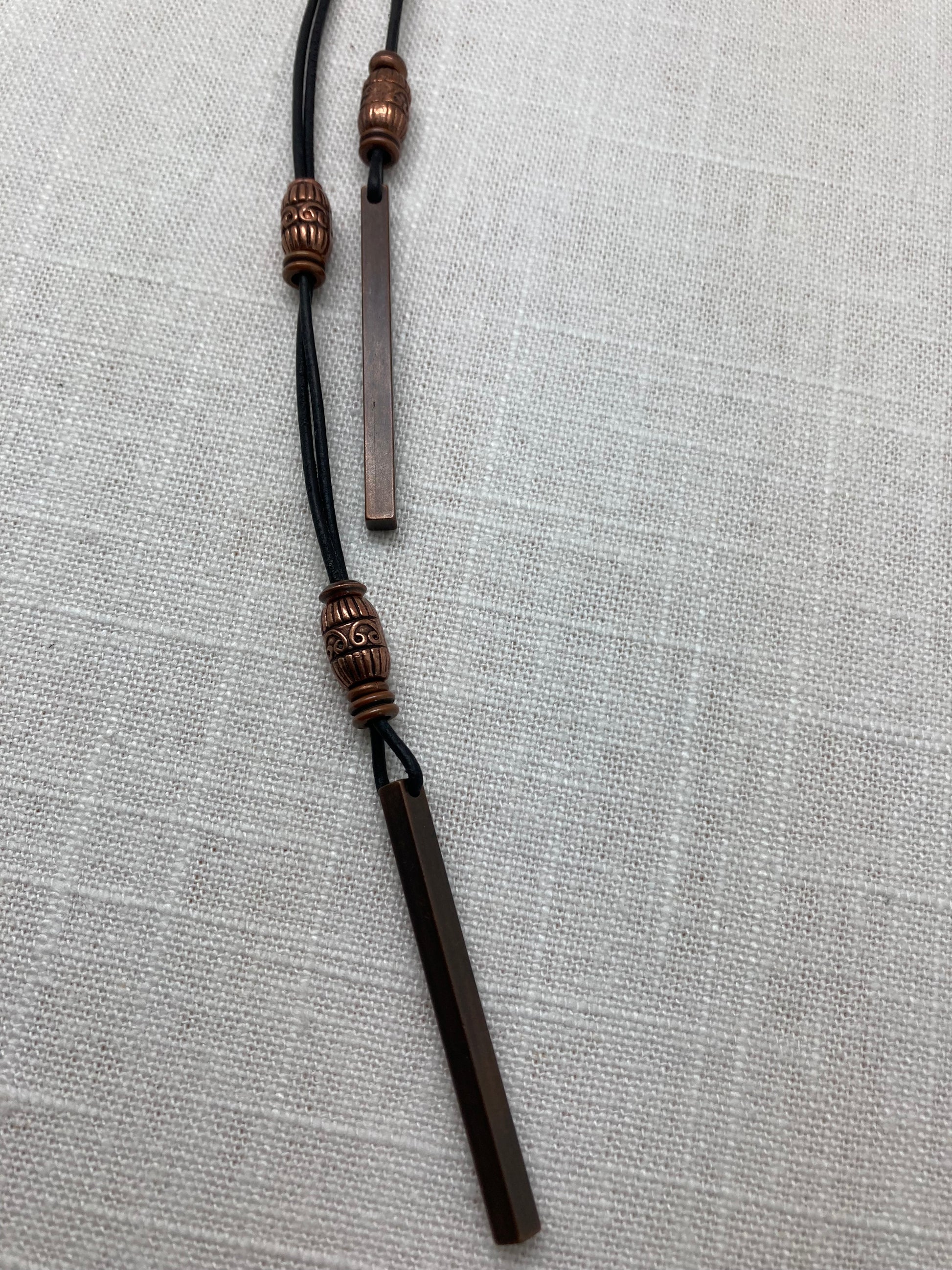 long leather necklace with copper beads and bar