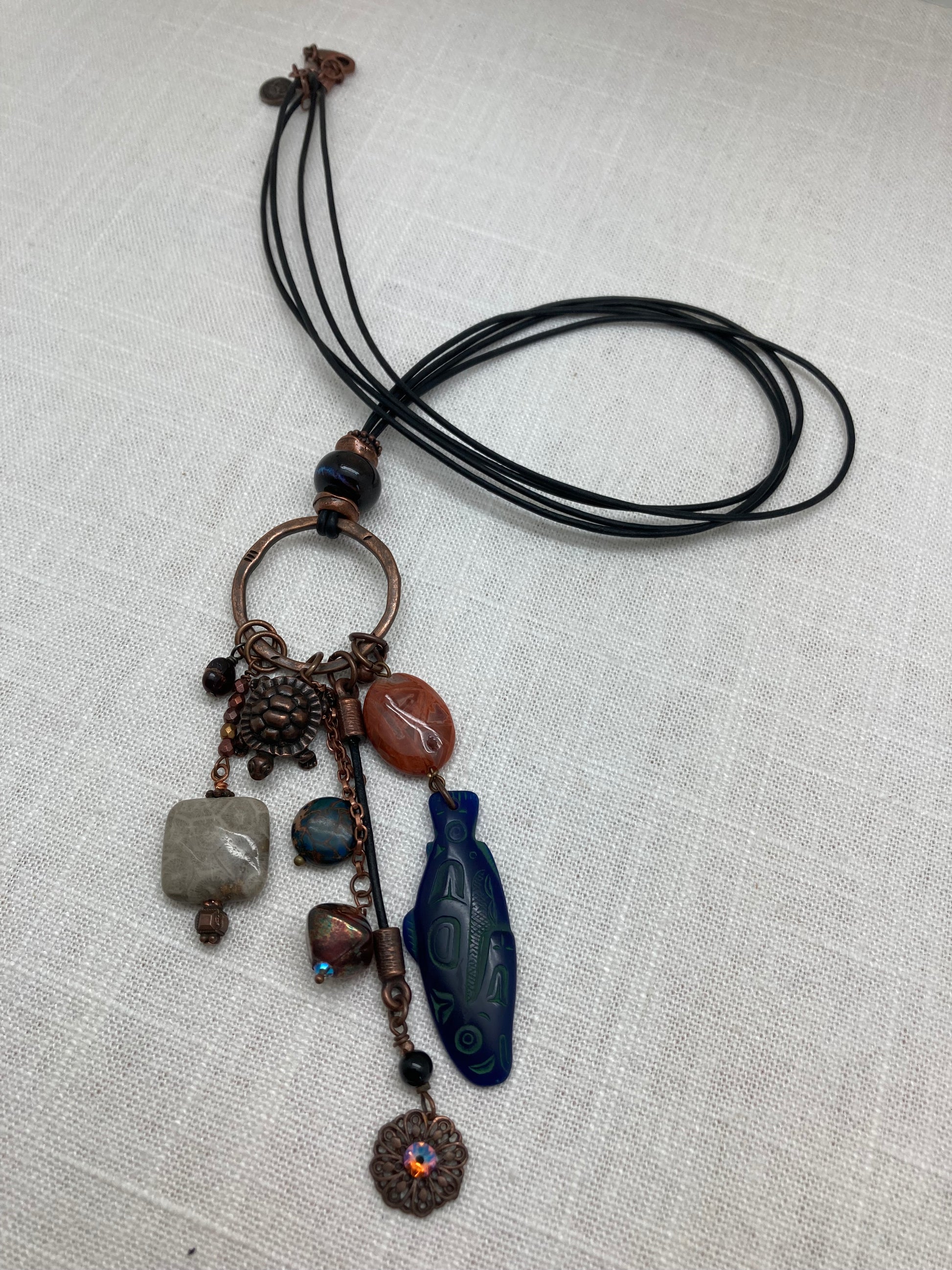 leather necklace with fish and turtle charms on copper ring