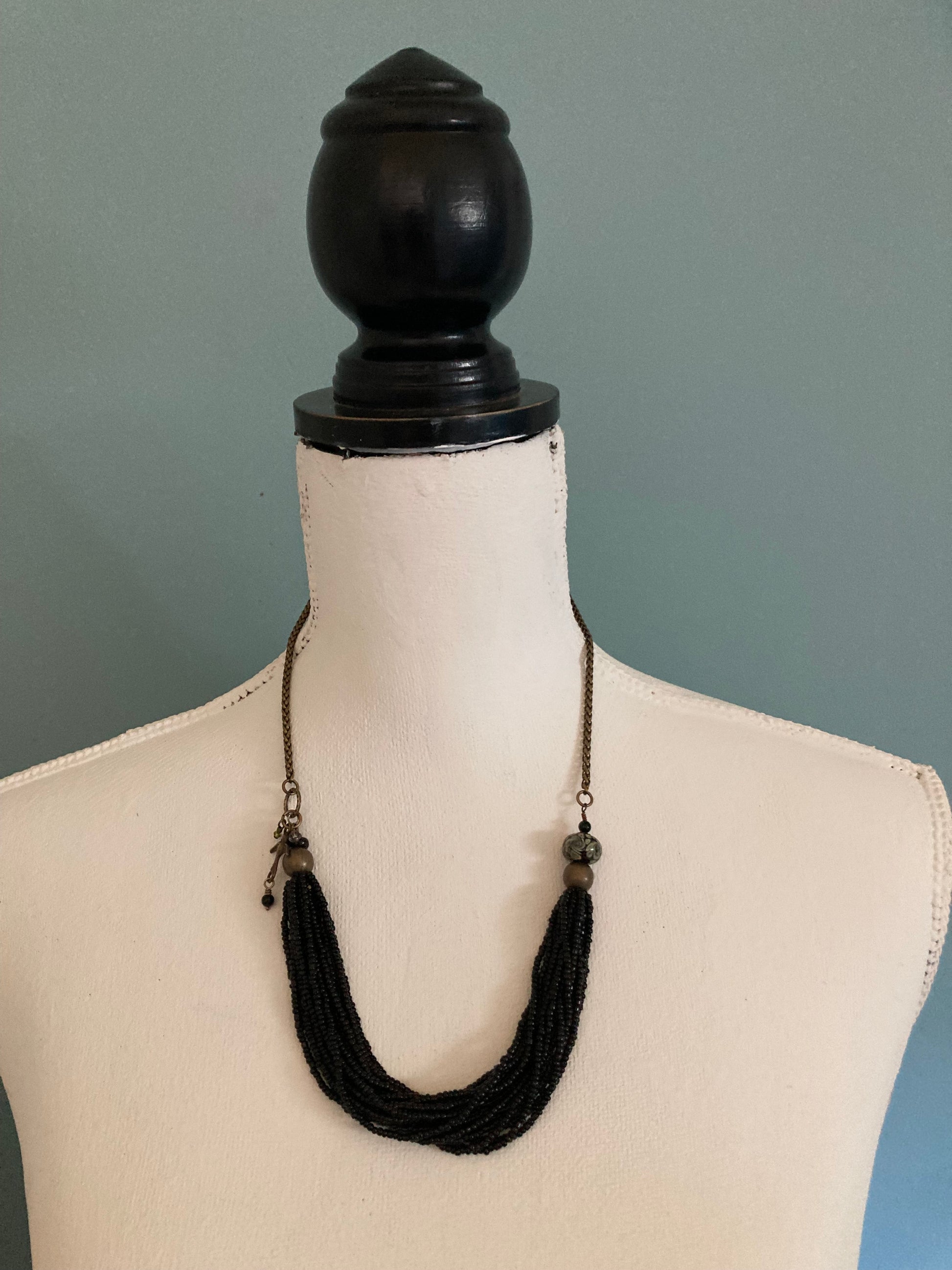 black and brass beaded necklace with glass and bird