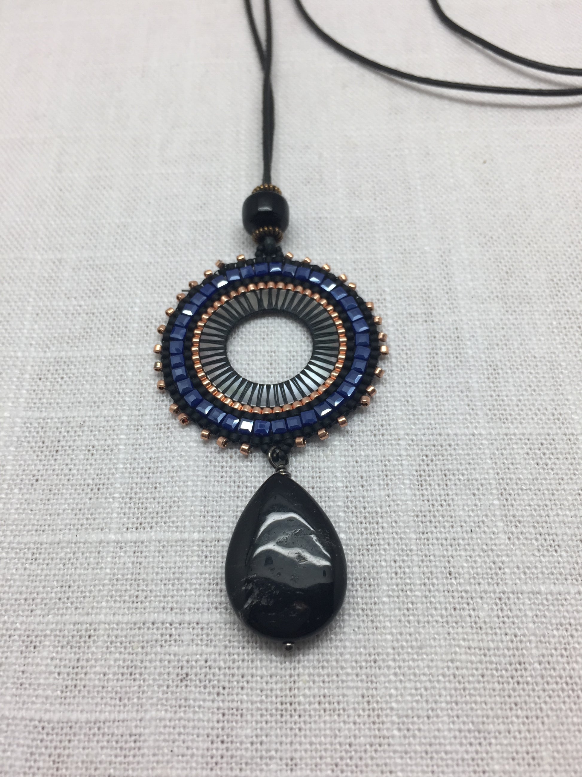 leather necklace with black onyx pendant and cobalt and orange accents