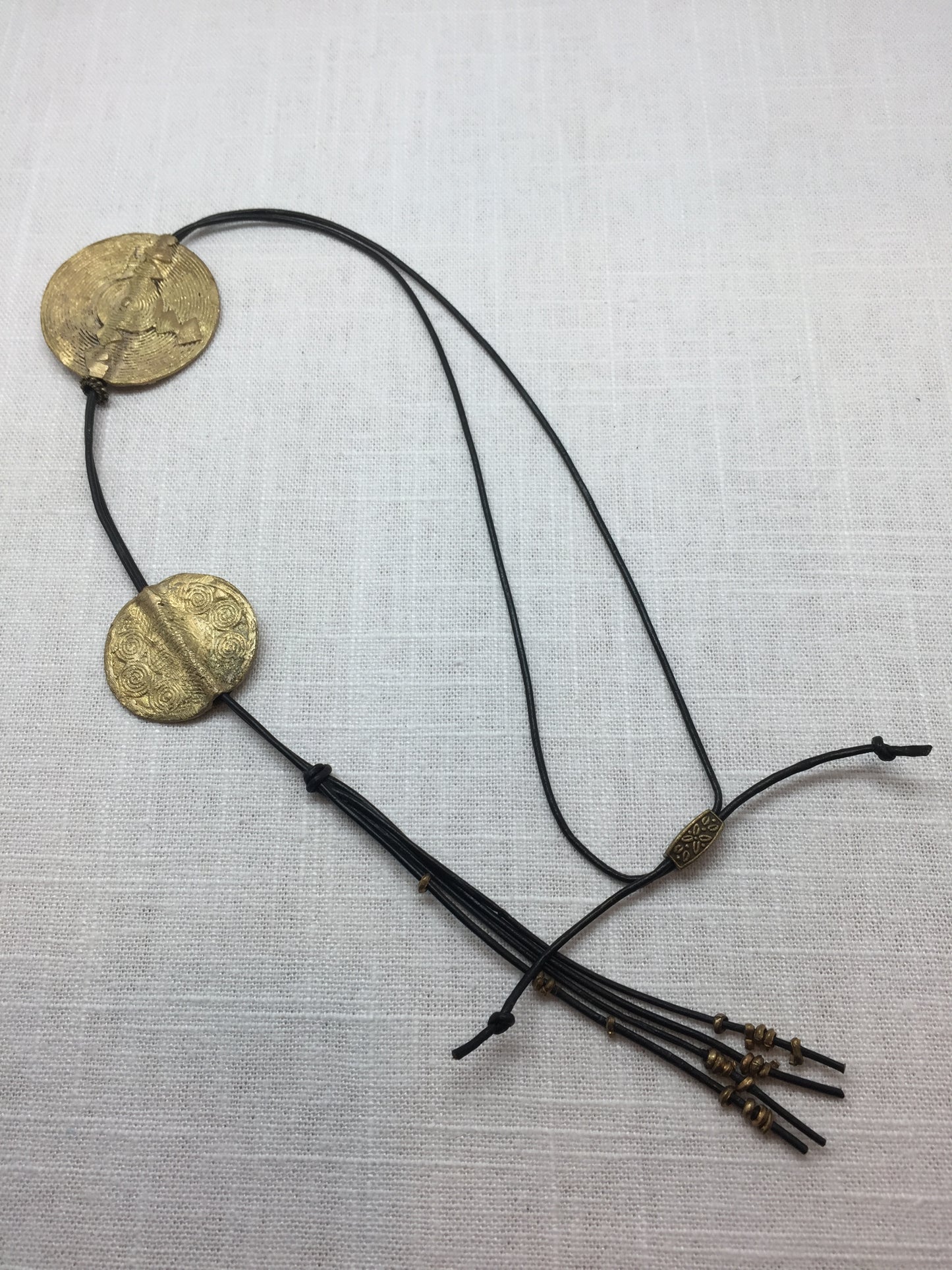 Long leather necklace with geometric stamped brass medallions