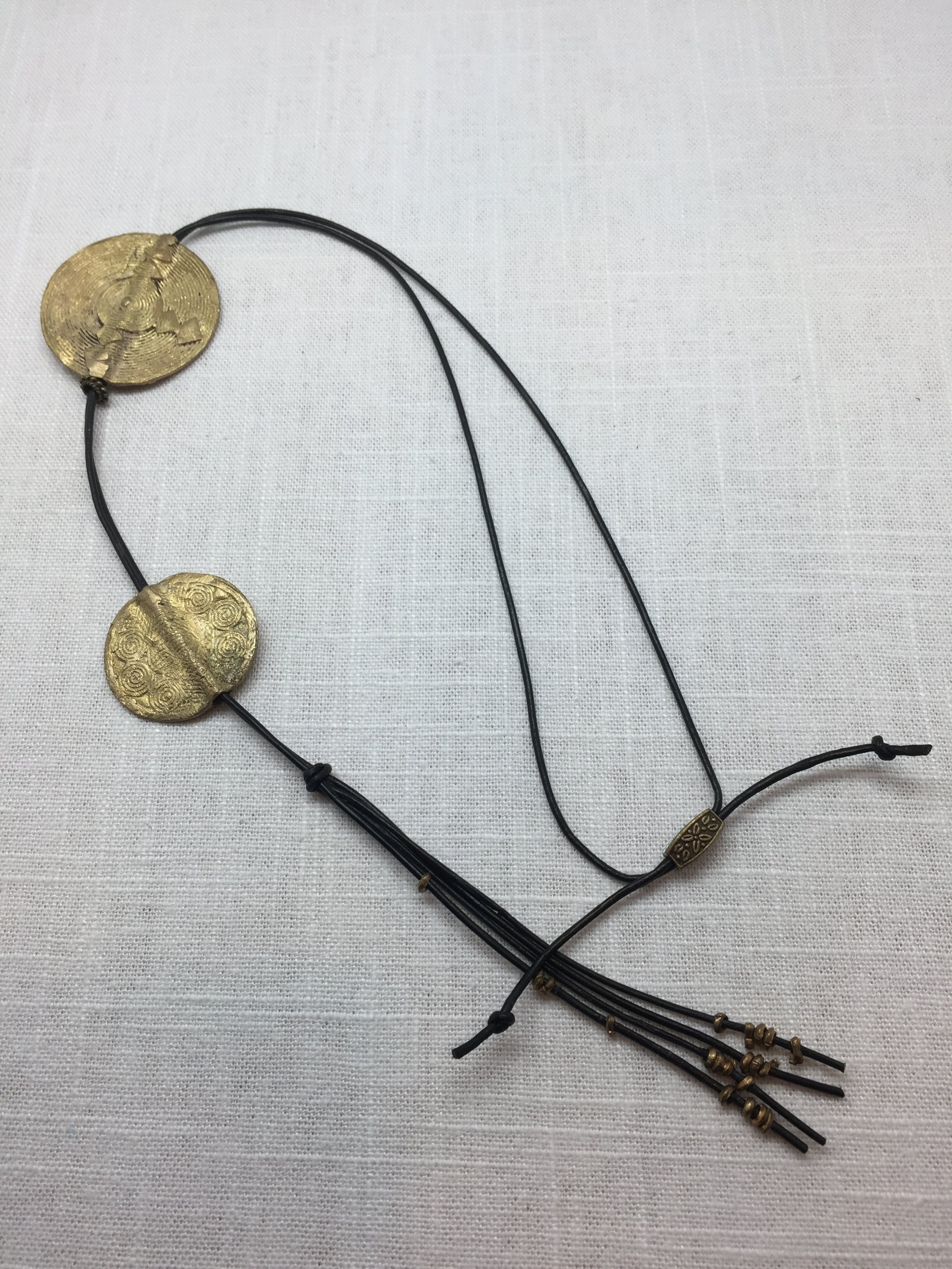 Long leather necklace with geometric stamped brass medallions