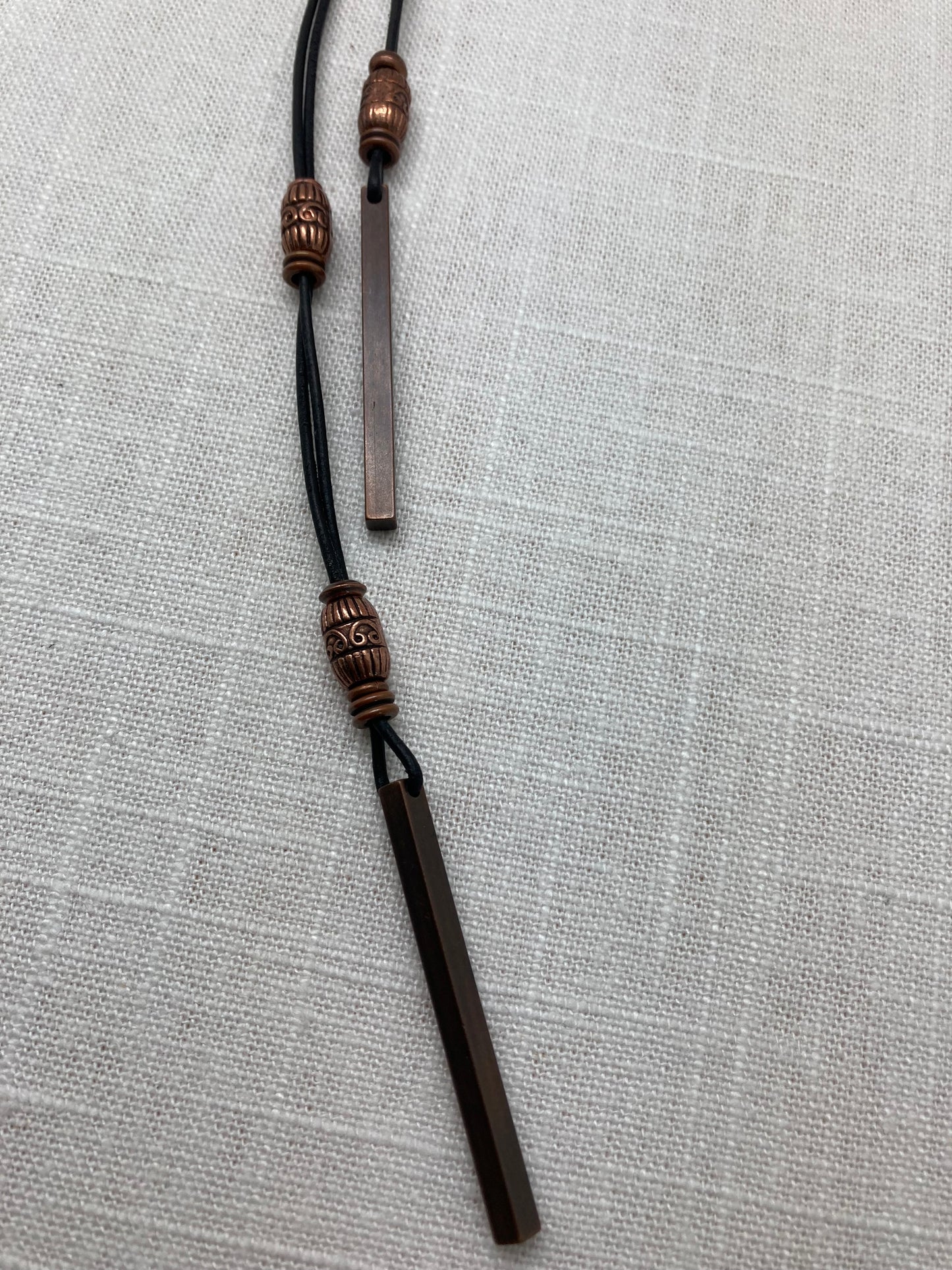 long leather necklace with copper beads and bar