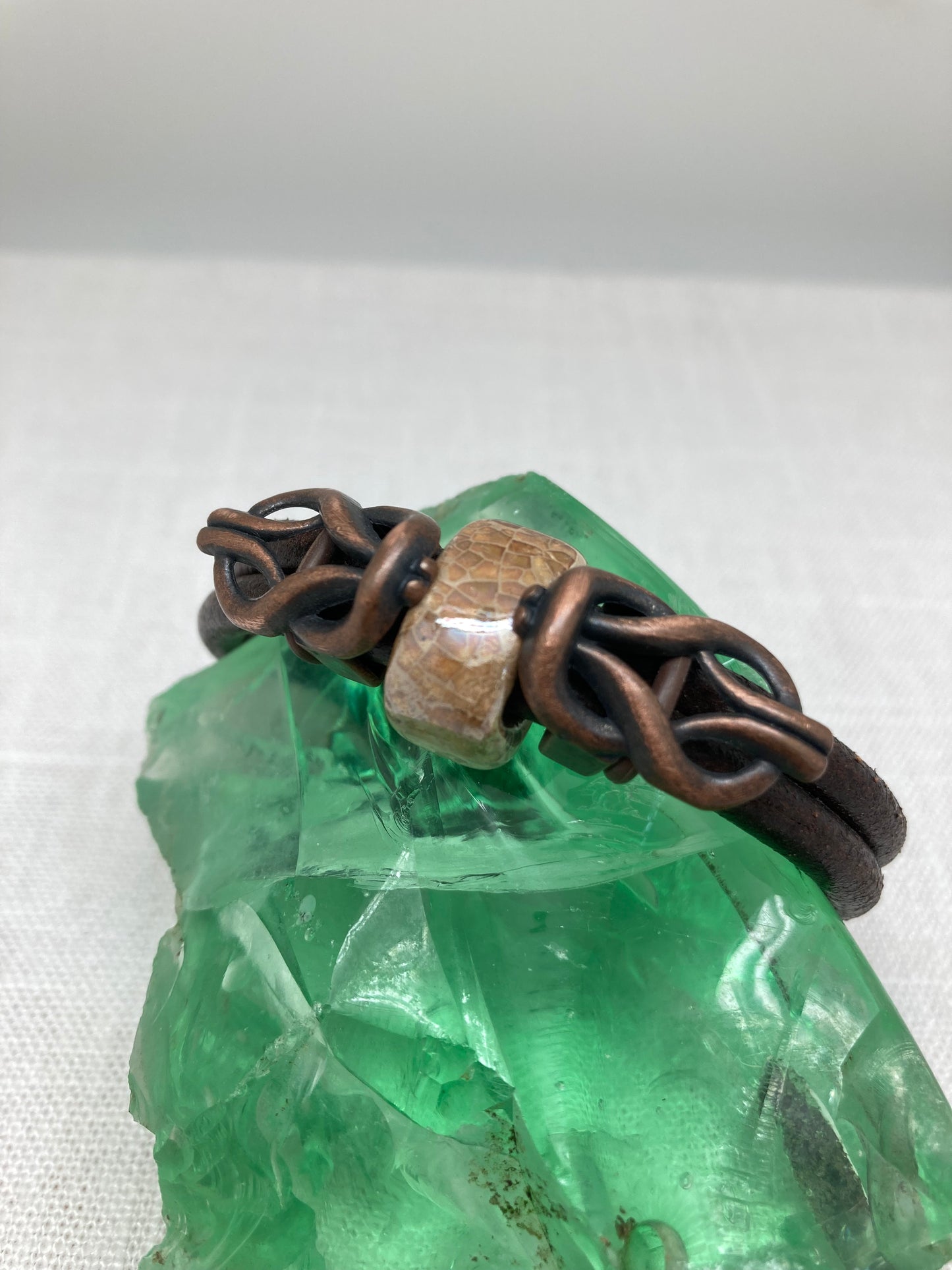 dark brown leather bracelet with light brown ceramic bead and copper knots